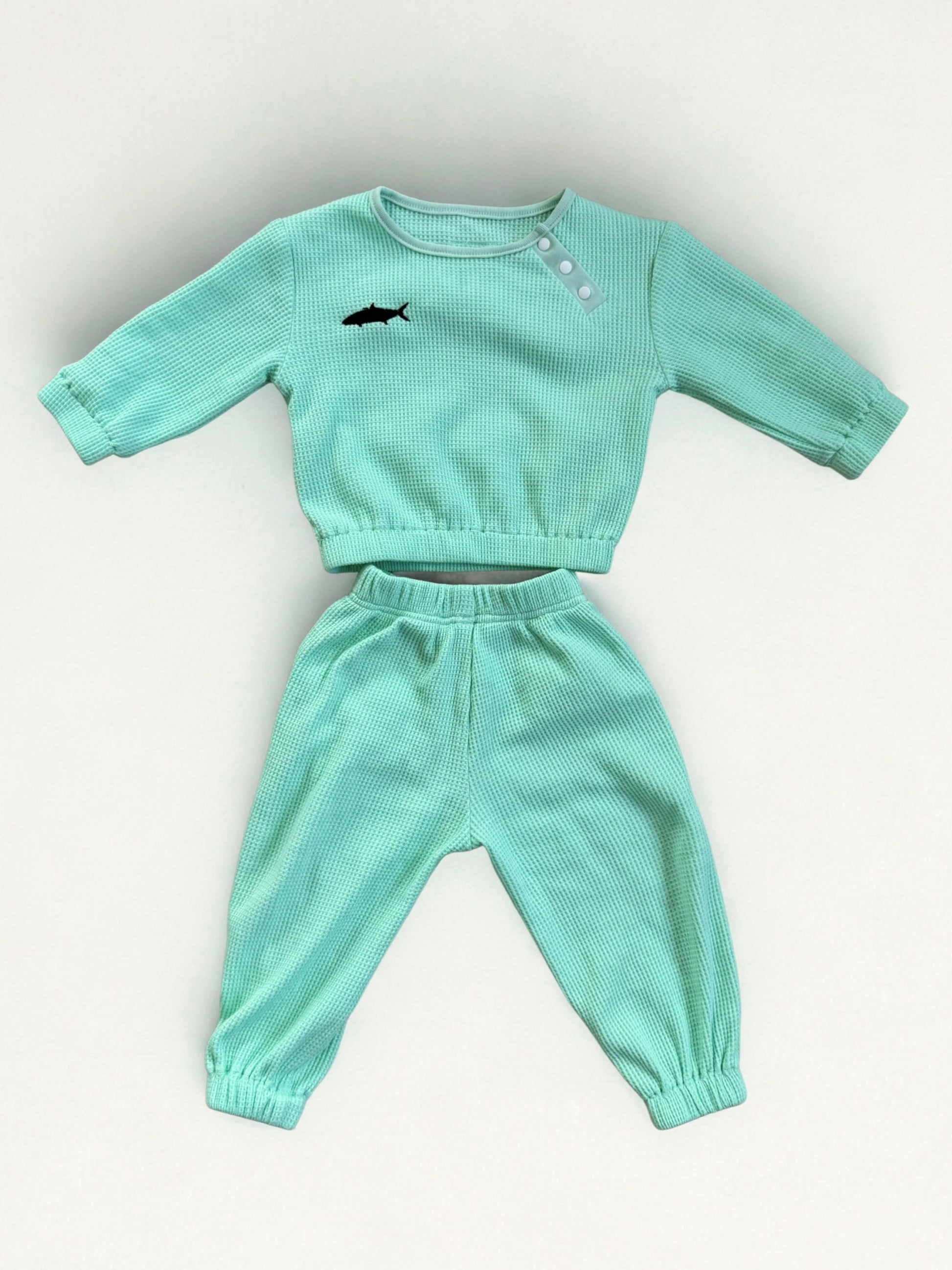 cyan children's sweatshirt and pants set on a light gray background